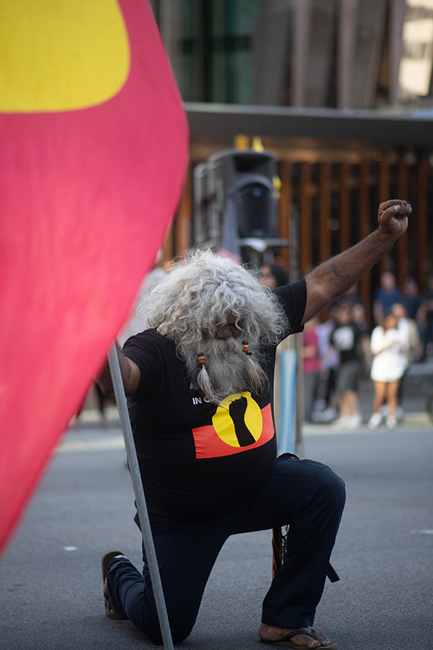 First Nations elder with flag at demonstration rally photographed by Cole Baxter | Nikon Cameras, Lenses & Accessories