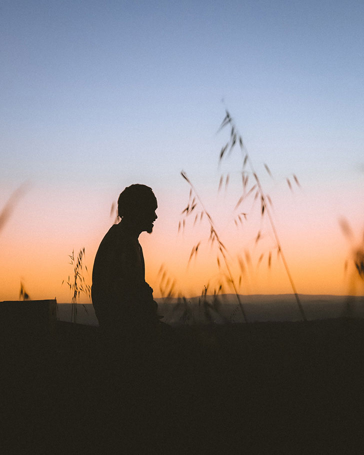 Man Sitting in a field at sunset by Anton Kollo | Nikon Cameras, Lenses & Accessories